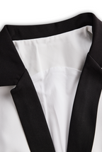 Elegante Tuta Bianca con Dettaglio Doppi Bottoni e Revers Nero